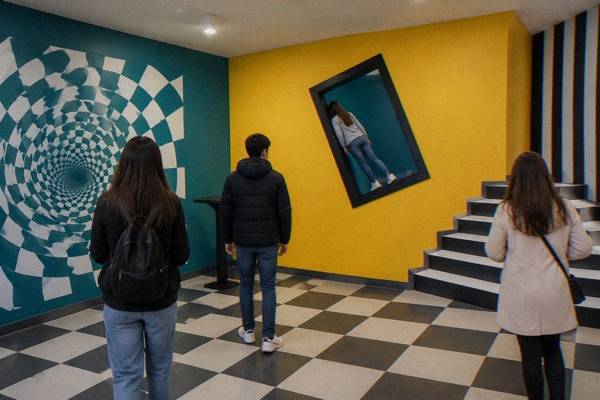 Bright indoor room with optical illusion installations, no people