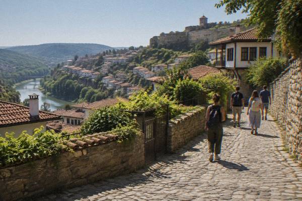 A small group walking uphill on a quiet cobbled street between stone walls and gardens, Varosha