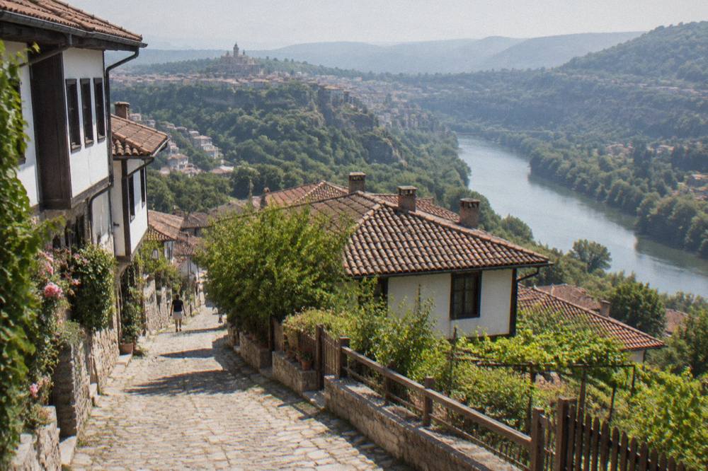 Cobbled street with old houses on a hillside above a river in Bulgaria