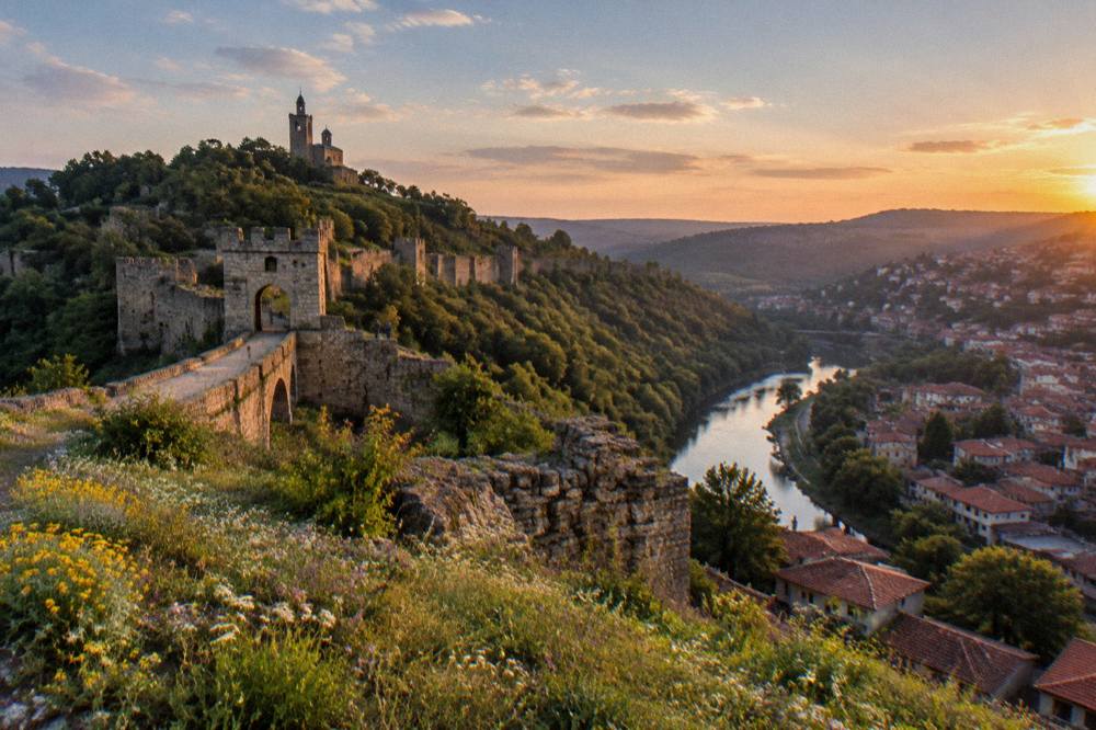 A panoramic view over an old town with fortress walls on a hill at dusk