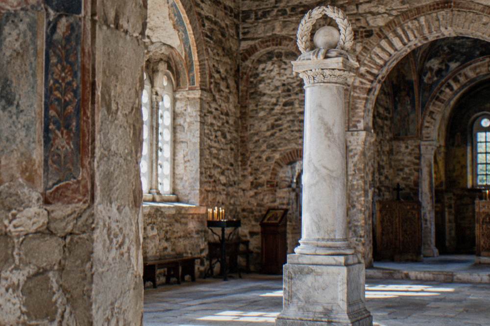 A marble victory column standing inside an old stone church interior