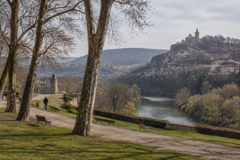 A river curving between forested hills with a town perched on the slopes