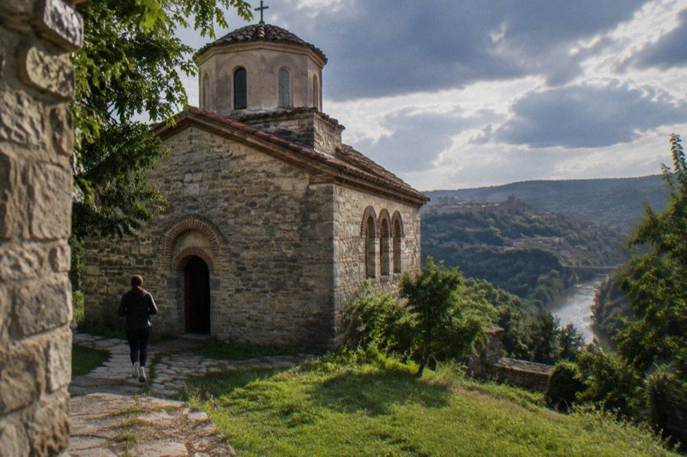 Close view of an old church facade with thick stone walls and a small arched doorway