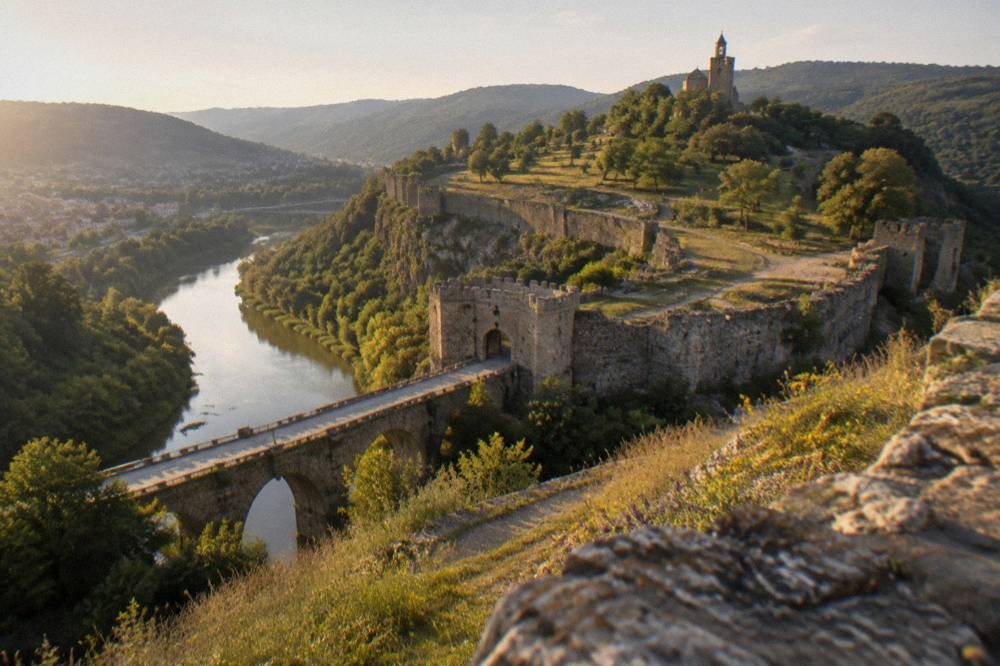 River curving between wooded hills with fortress walls on the heights above