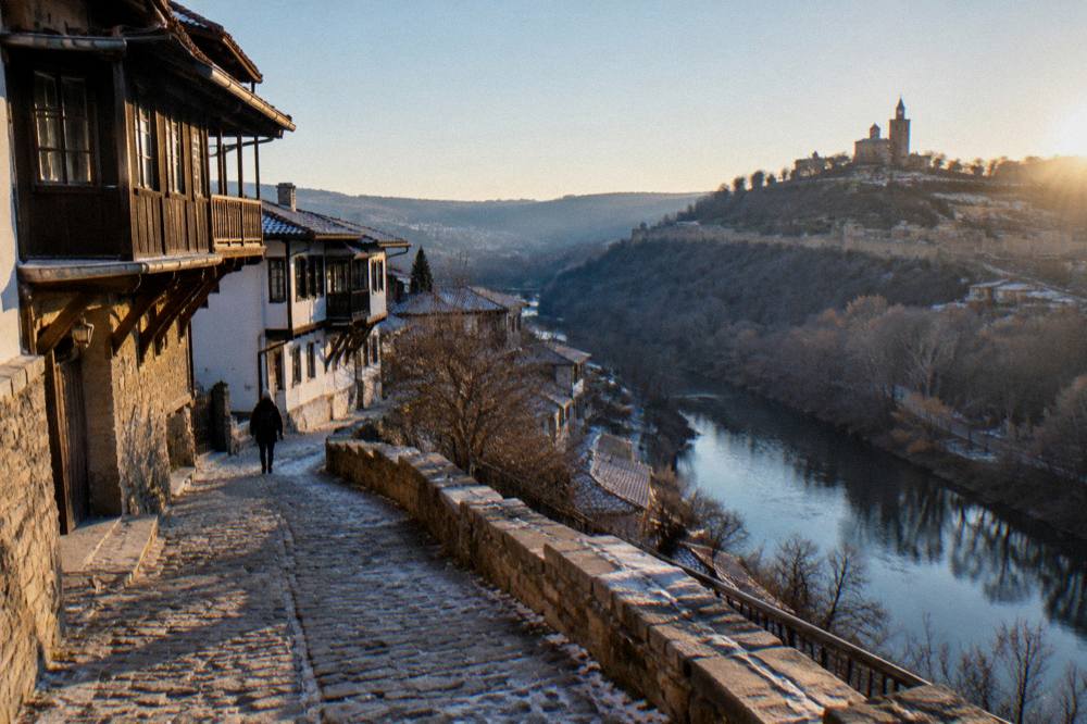 Evening lights on a fortress hill above a dark river bend in an old town