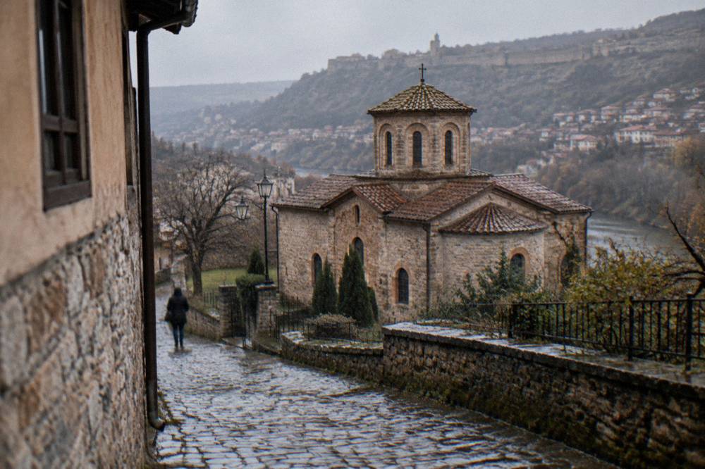 Narrow cobbled street leading toward an old church in a Bulgarian town