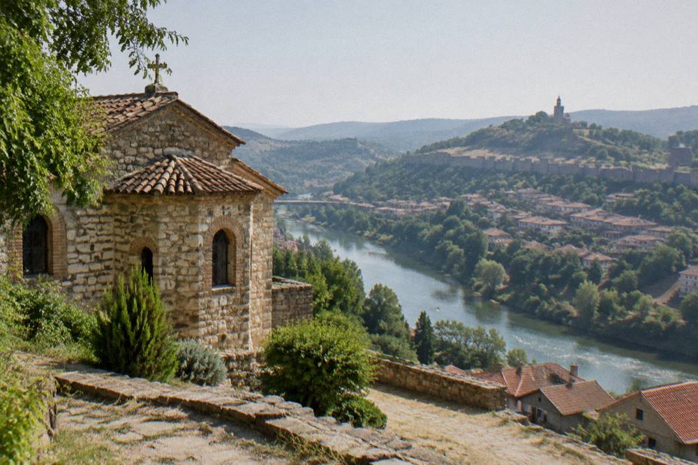 View across a river bend toward fortress walls on a hill above a town