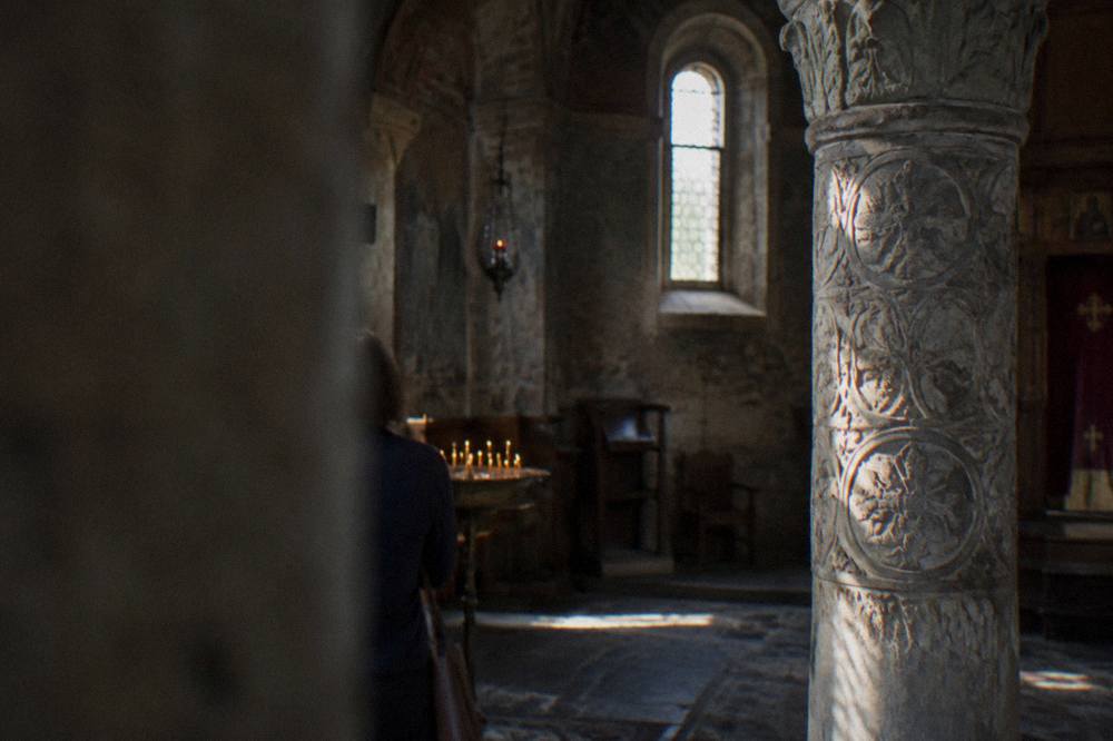 Carved marble column standing inside a dim medieval church interior