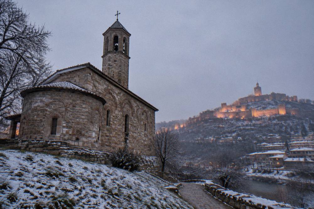 Evening light show illuminating a fortress hill above a dark city