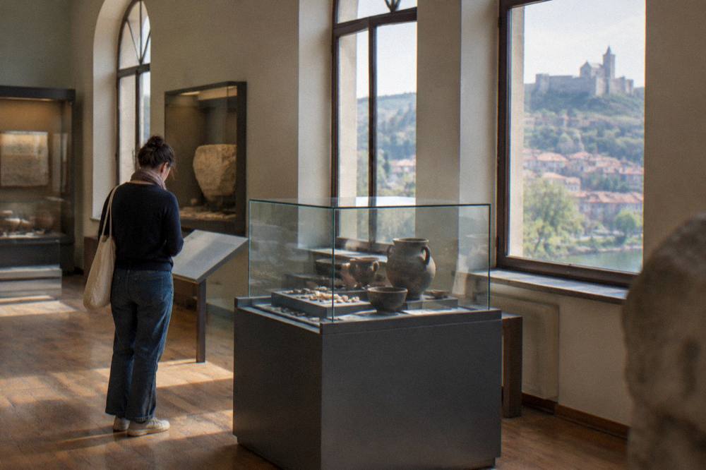 A visitor reading an information panel beside a glass case of archaeological finds