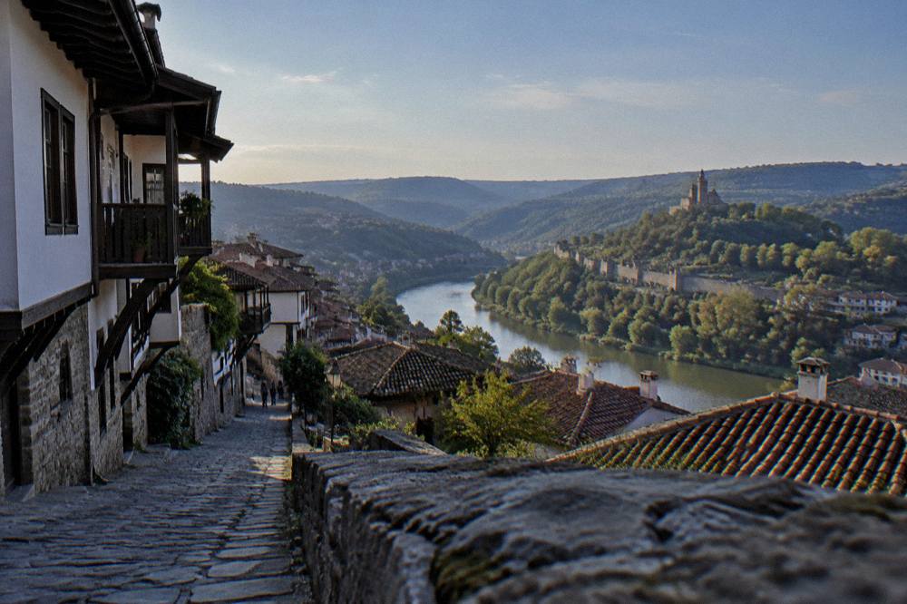 A panoramic view over the roofs and hills of Veliko Tarnovo with the Yantra river curving between the ridges