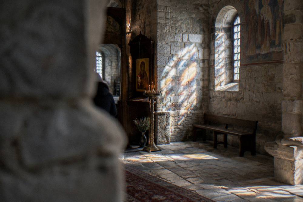 The interior of a small stone church lit by projected patterns of light
