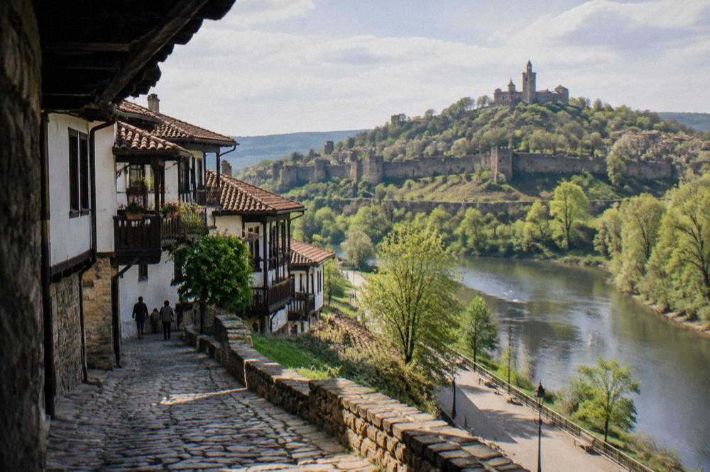 A riverside park path in Veliko Tarnovo with the fortress hill rising above the Yantra