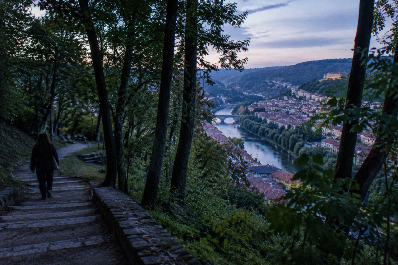 Wooded hillside rising above the rooftops and river bends of a historic Bulgarian town
