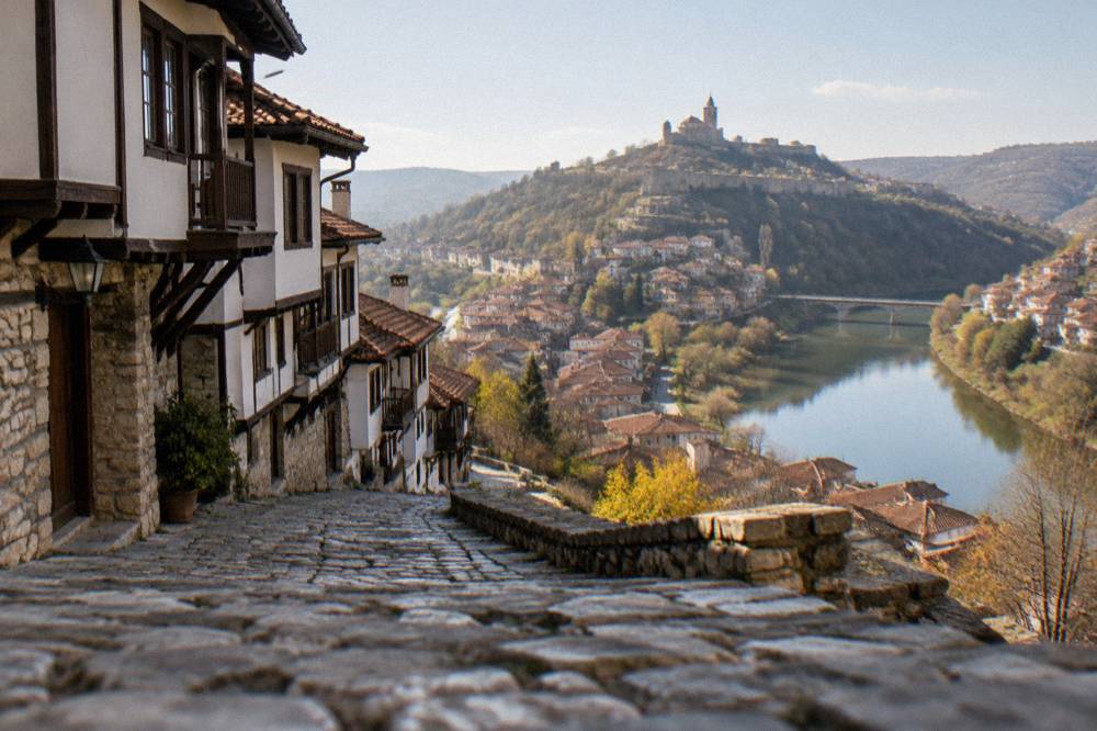 Aerial view of a fortress-topped hill and a river loop encircling old town rooftops