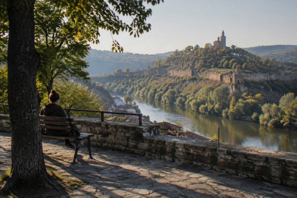 A wide stone terrace overlooking a hilltop fortress across a river valley