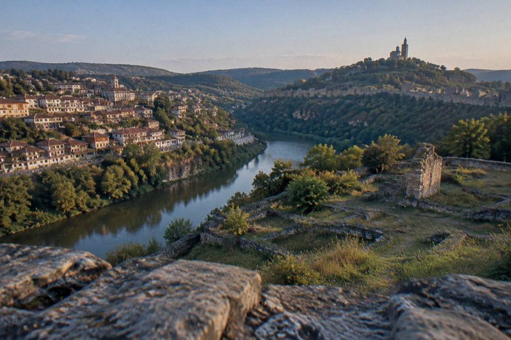 View across the Yantra river bend toward the walls of Tsarevets from the Trapezitsa side of Veliko Tarnovo