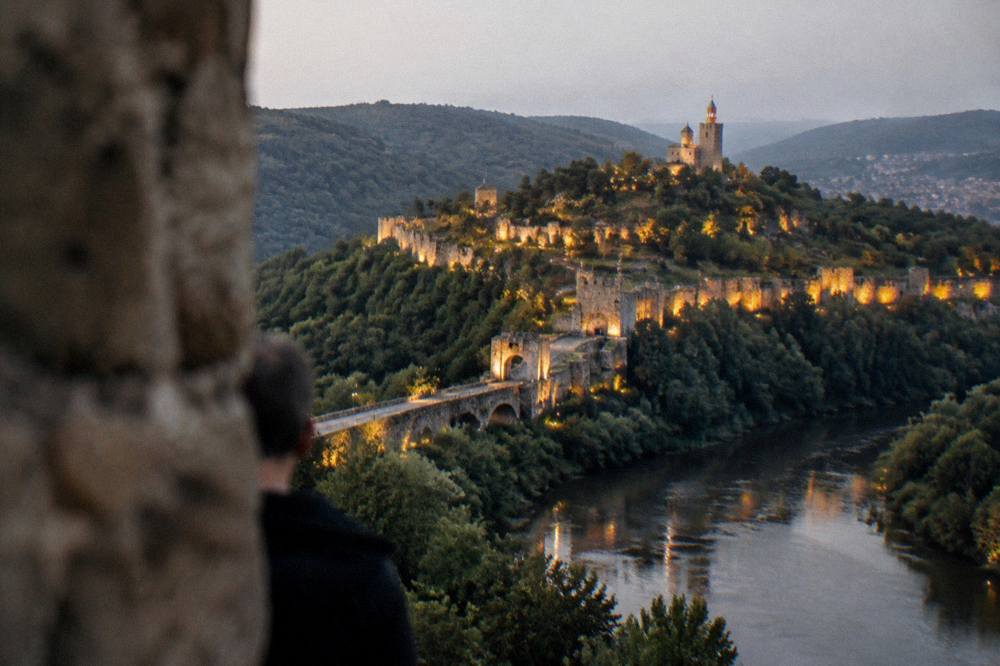 Evening view of illuminated fortress walls above the Yantra river in Veliko Tarnovo