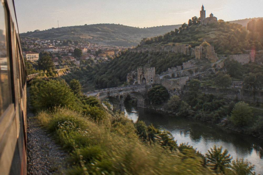 A train travelling through the hilly countryside of northern Bulgaria towards Veliko Tarnovo