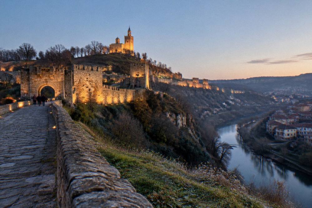 The illuminated fortress walls of Tsarevets during an evening light show over Veliko Tarnovo