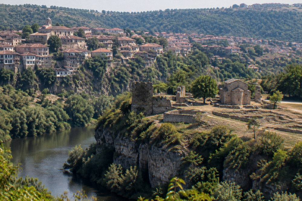 A village church and stone houses on a plateau above a river valley