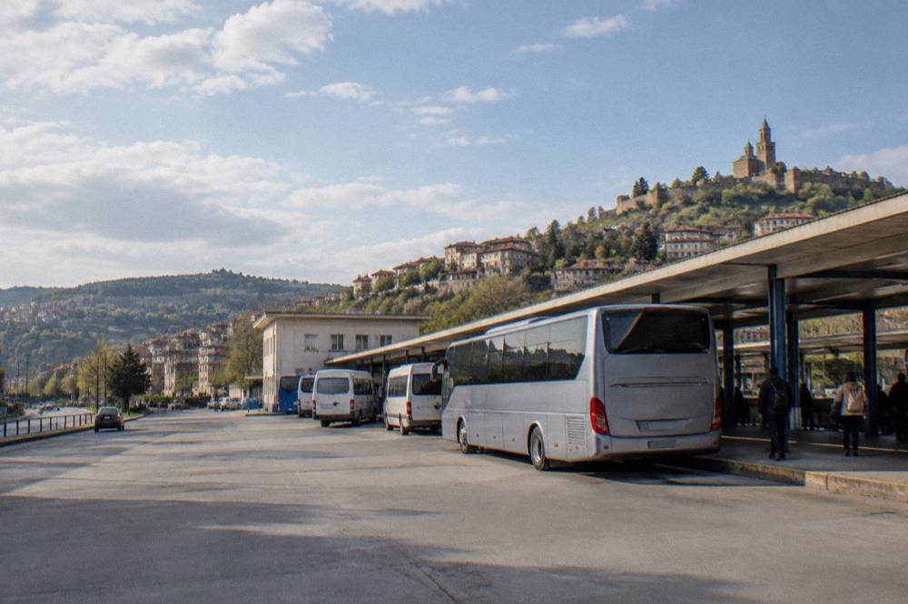 A long-distance coach parked at a bus station platform beside departure boards