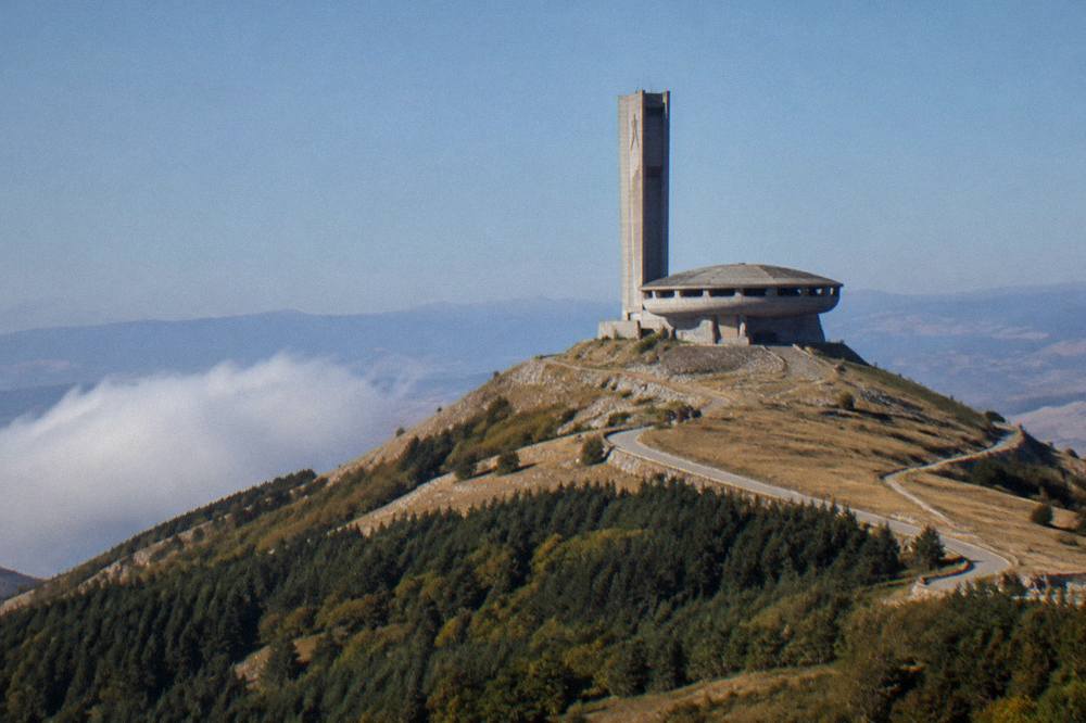 A concrete tower on a hilltop against a clear blue sky
