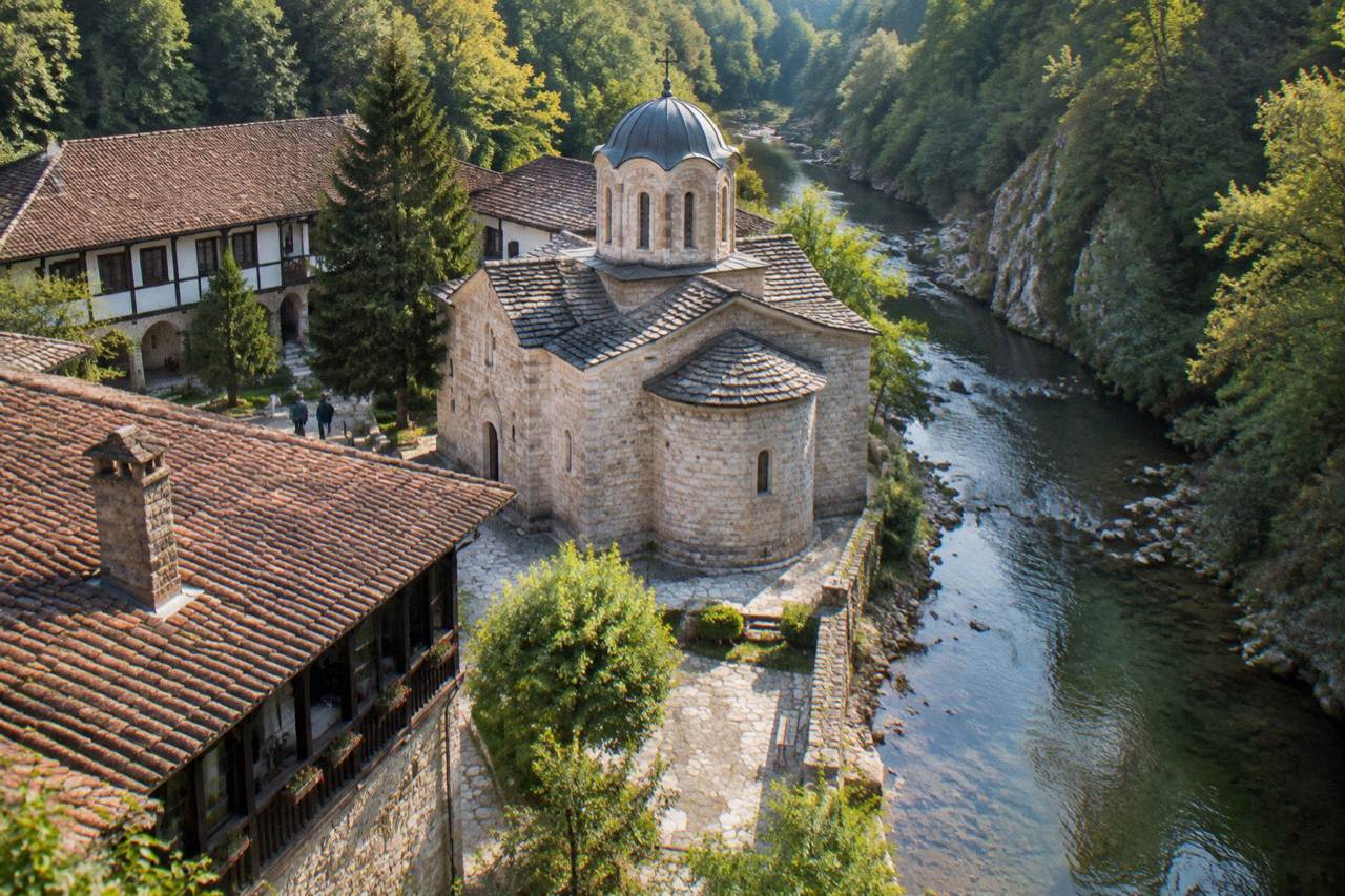 A Bulgarian Orthodox monastery church beside a wooded river gorge