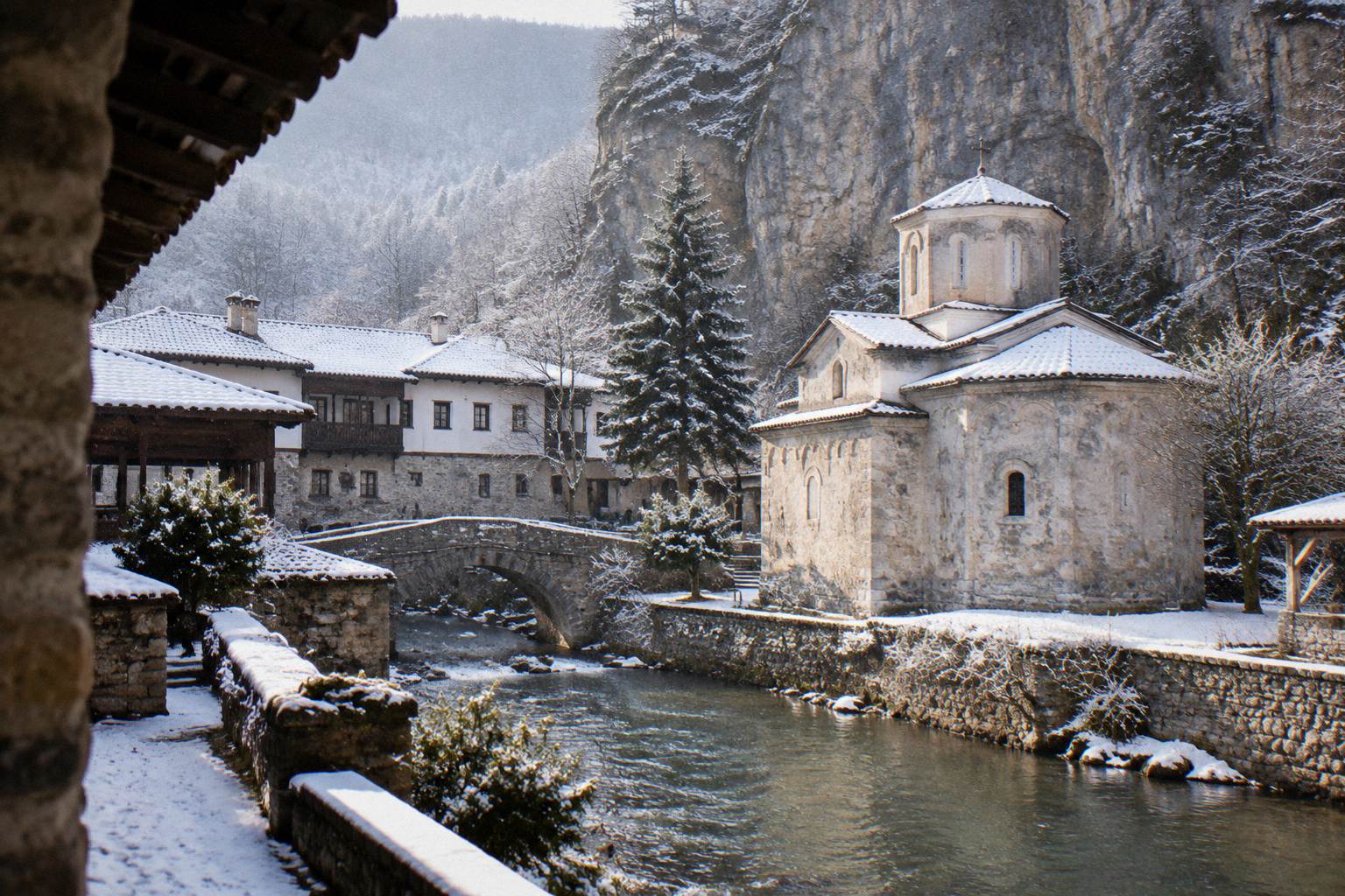 Orthodox monastery tucked under a limestone cliff in a green river valley