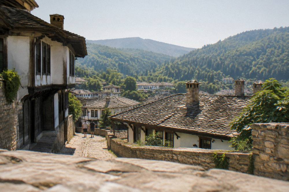 A view over rooftops and hills from a high street in a Bulgarian town