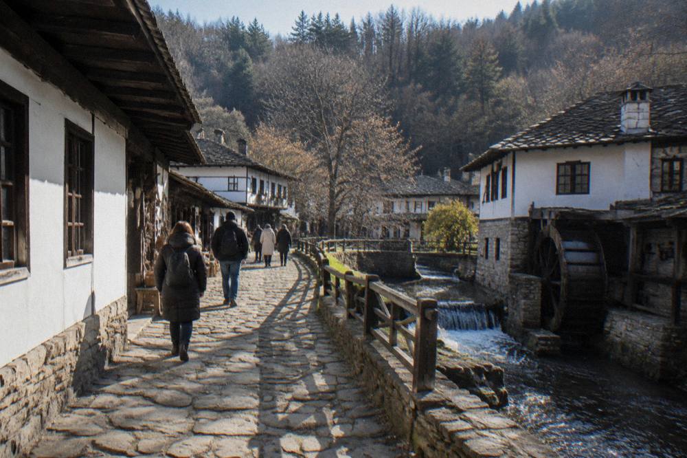Visitors walking past whitewashed museum buildings along a craft street