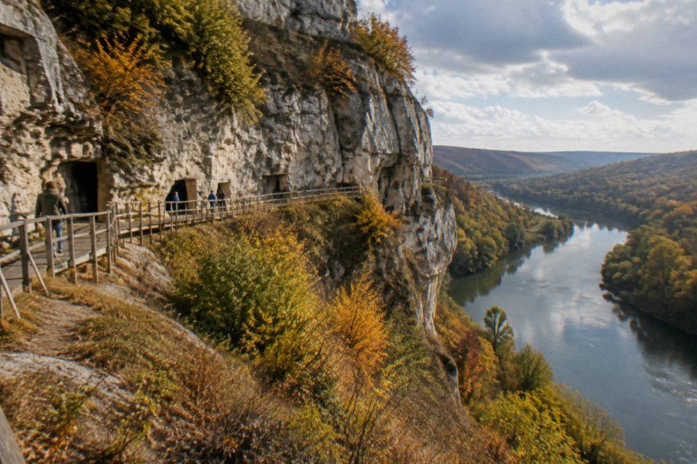 Cliff face in autumn colours above a calm river bend