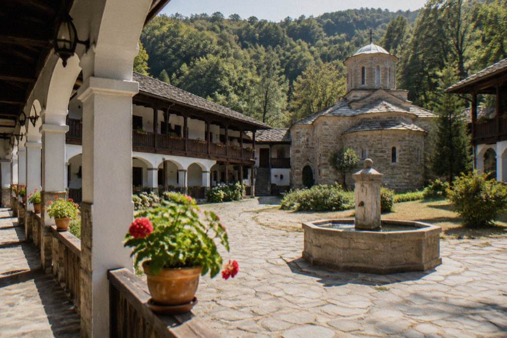 A monastery courtyard with a fountain and covered walkways under an arcade