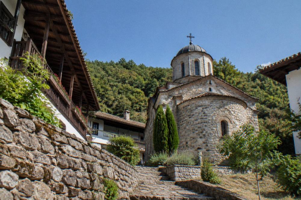 A small Orthodox church dome with a cross against a blue sky