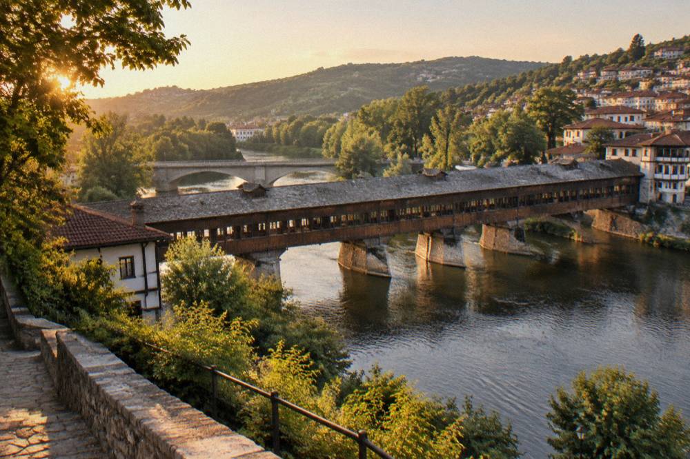 A stone bridge and riverbank trees seen from a hillside path in a Bulgarian town
