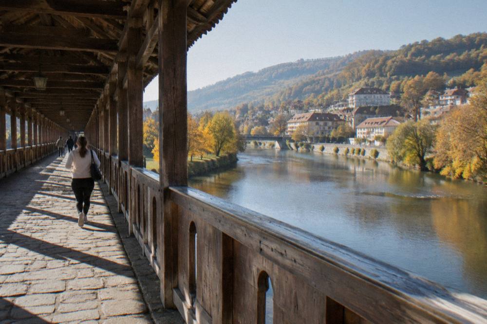 A river flowing under a town bridge with autumn trees on both banks