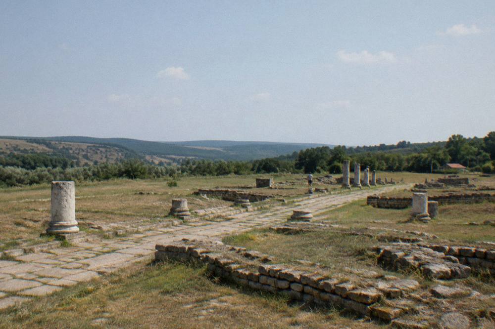 Ancient stone outlines stretching across a quiet field at the edge of a village