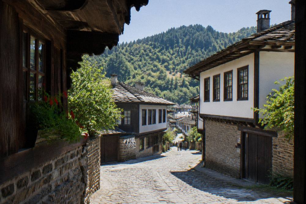 A cobbled street lined with wooden houses in a historic Bulgarian town