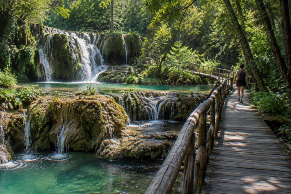 Turquoise waterfalls cascading over travertine terraces at Krushuna Falls