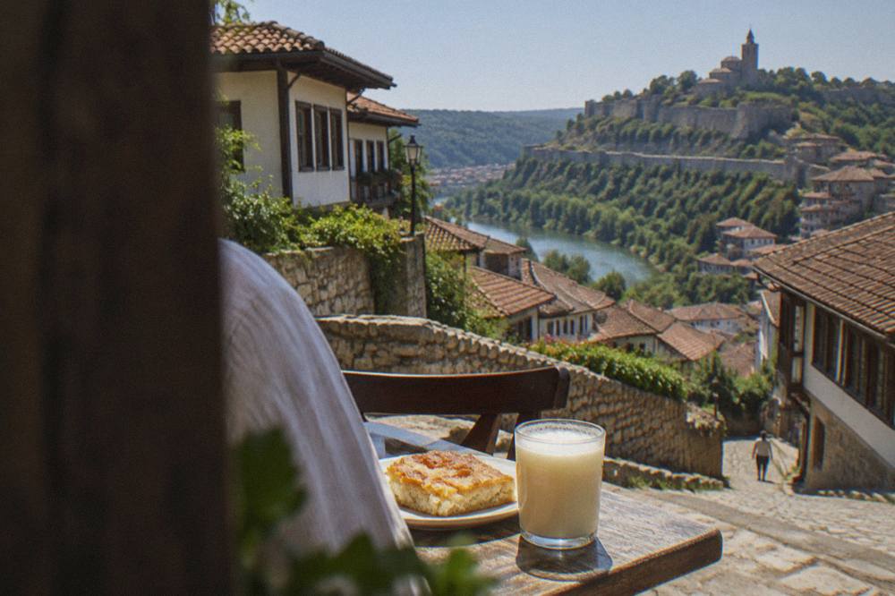 A cup of thick boza beside a piece of cheese banitsa on a small table