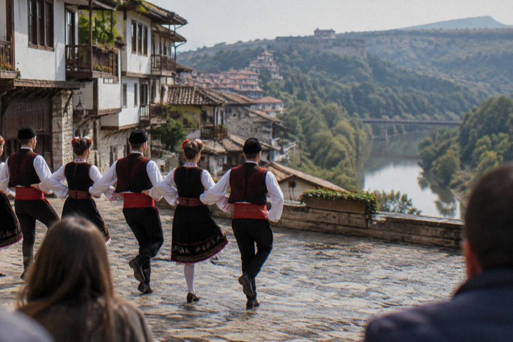 Folk dancers in traditional costume performing in an outdoor Veliko Tarnovo square