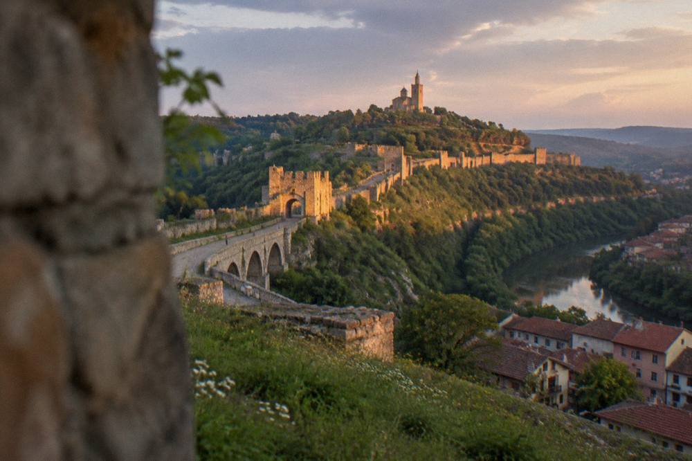 Lit fortress walls of Tsarevets above the city at dusk