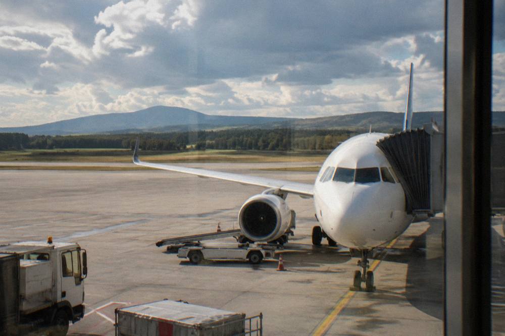 Plane parked at an airport terminal gate seen from the window of the airbridge