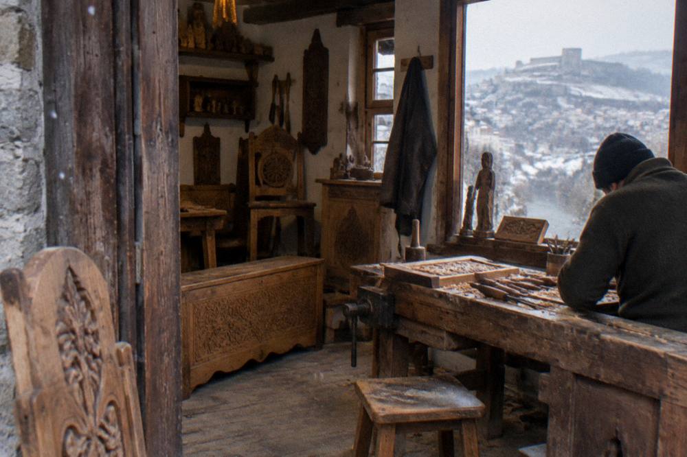 A woodcarver's workshop interior with carved furniture and tools on a workbench