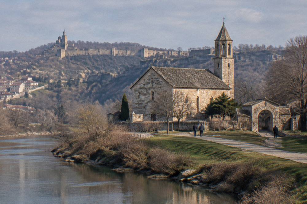 The stone facade and arched gate of the Church of the Holy Forty Martyrs beside the river