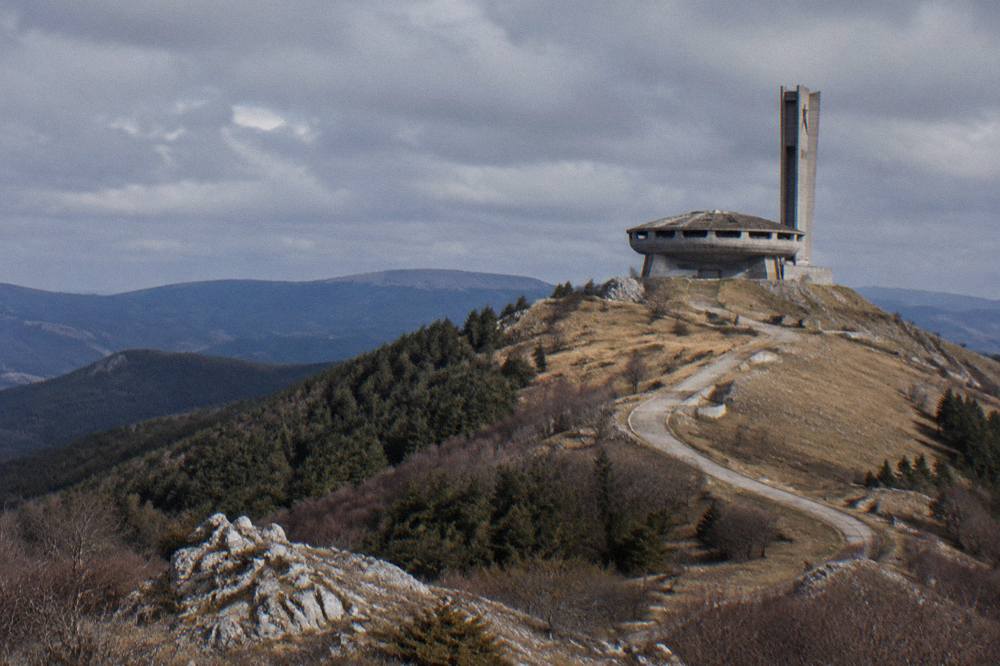 The abandoned saucer-shaped Buzludzha monument on a mountain ridge under a wide sky