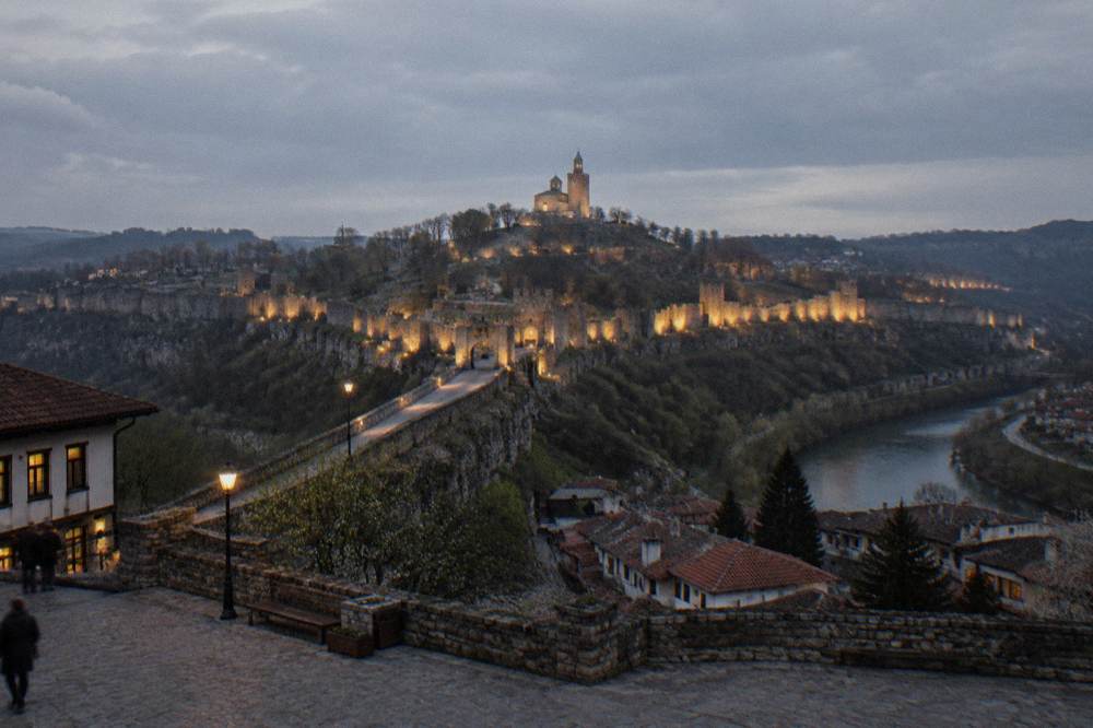 Evening light on the illuminated walls of Tsarevets Fortress during the Sound and Light show, seen from a darkened city square