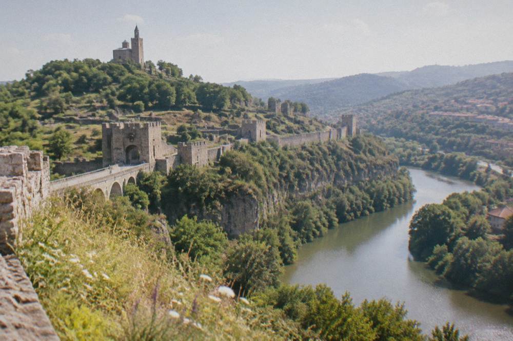 Stone fortification walls of Tsarevets Fortress above the river bend in daylight