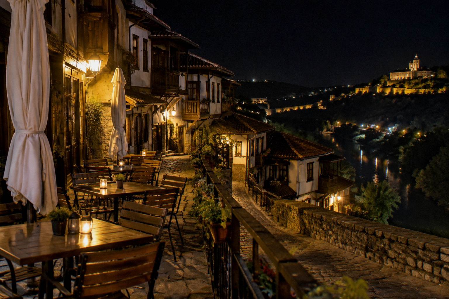 Outdoor cafe terrace in an old-town lane at night, empty chairs