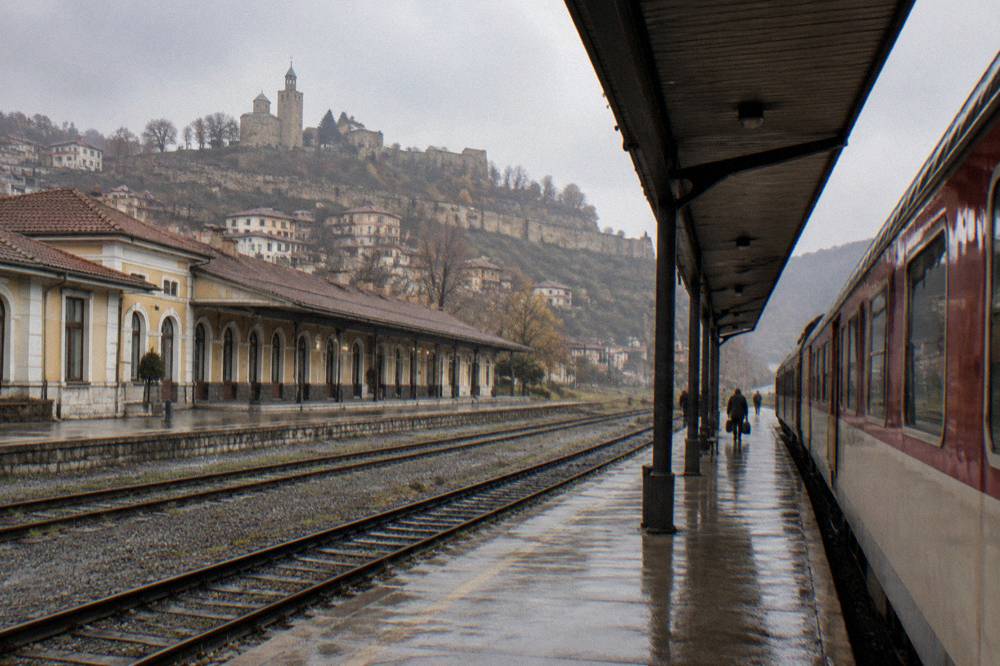 An intercity train waiting at a platform beside a station canopy in daylight